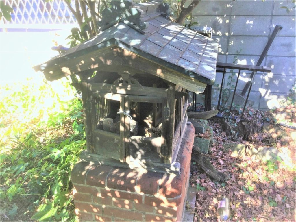 家の敷地に祀られたお稲荷様の古い祠とキツネ像